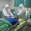 man in white medical scrub lying on hospital bed