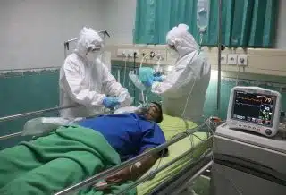 man in white medical scrub lying on hospital bed