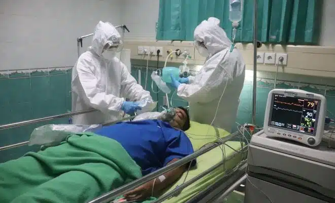 man in white medical scrub lying on hospital bed